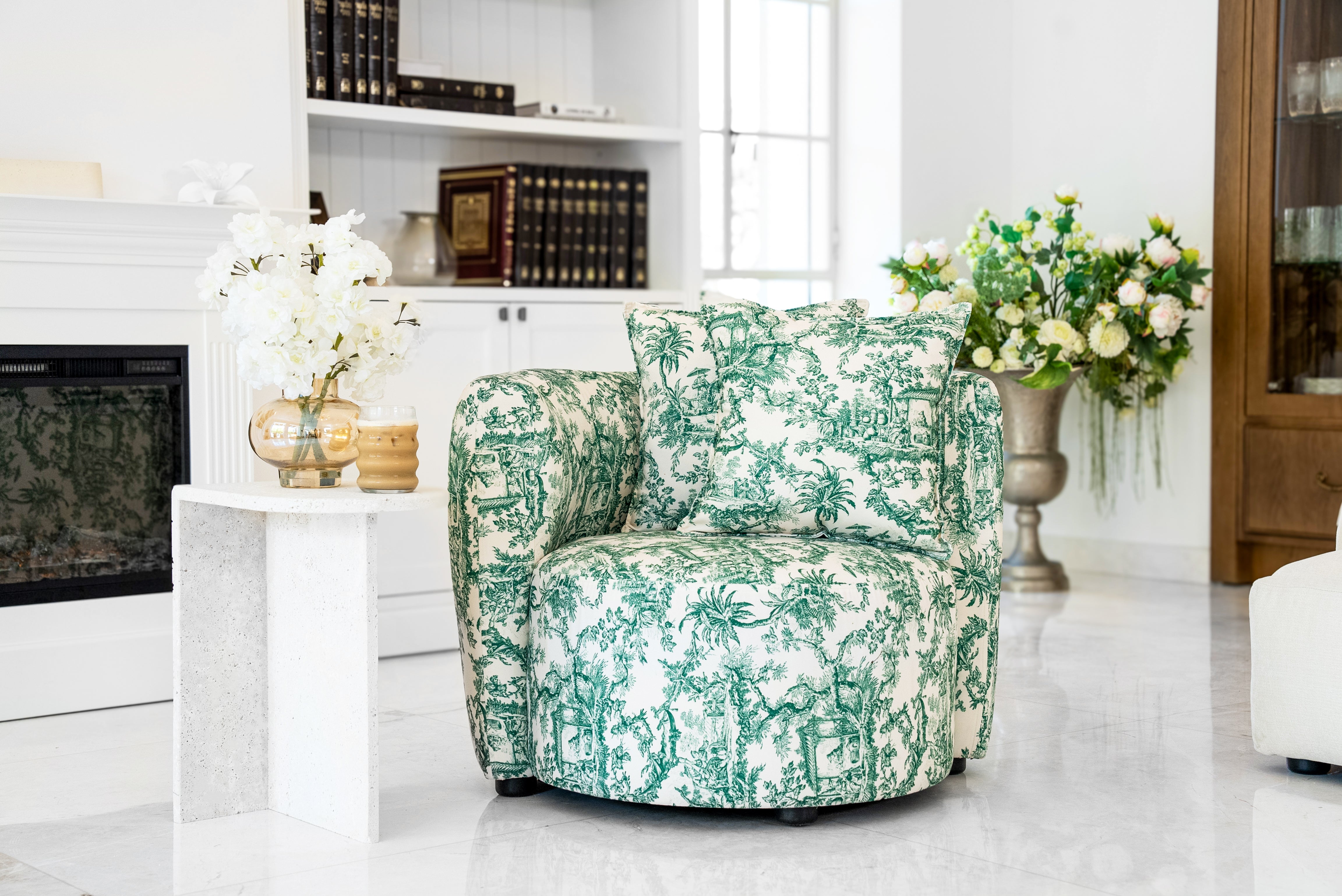 

"Green Twall armchair featuring a stunning green and white tropical french toile print. This -style chair boasts a rounded silhouette, plush cushioning, and matching accent pillows, offering a perfect blend of comfort and sophistication for modern interiors."