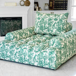 Joey Twal chaise lounge featuring a plush, oversized design upholstered in a striking green and white toile print fabric. The chaise showcases deep button tufting, a high backrest, and ample seating space, perfect for comfortable relaxation in sophisticated interiors
