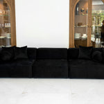 "NOIR sofa featuring luxurious black velvet upholstery, modular design with three sections, and plush cushions. Sleek modern couch set against wooden display cabinets in a bright, contemporary living space." CopyRetryDMתרגם לעבריתEditכותרת המוצר:
"ספת NOIR - ספה מודולרית אלגנטית מקטיפה שחורה לסלון מודרני"
טקסט ALT:
"ספת NOIR המציגה ריפוד קטיפה שחורה יוקרתית, עיצוב מודולרי עם שלושה חלקים, וכריות רכות ומפנקות. ספה מודרנית מסוגננת על רקע ארונות תצוגה מעץ בחלל מגורים בהיר ועכשווי." CopyRetryDMכמומחה SEO תן כותר