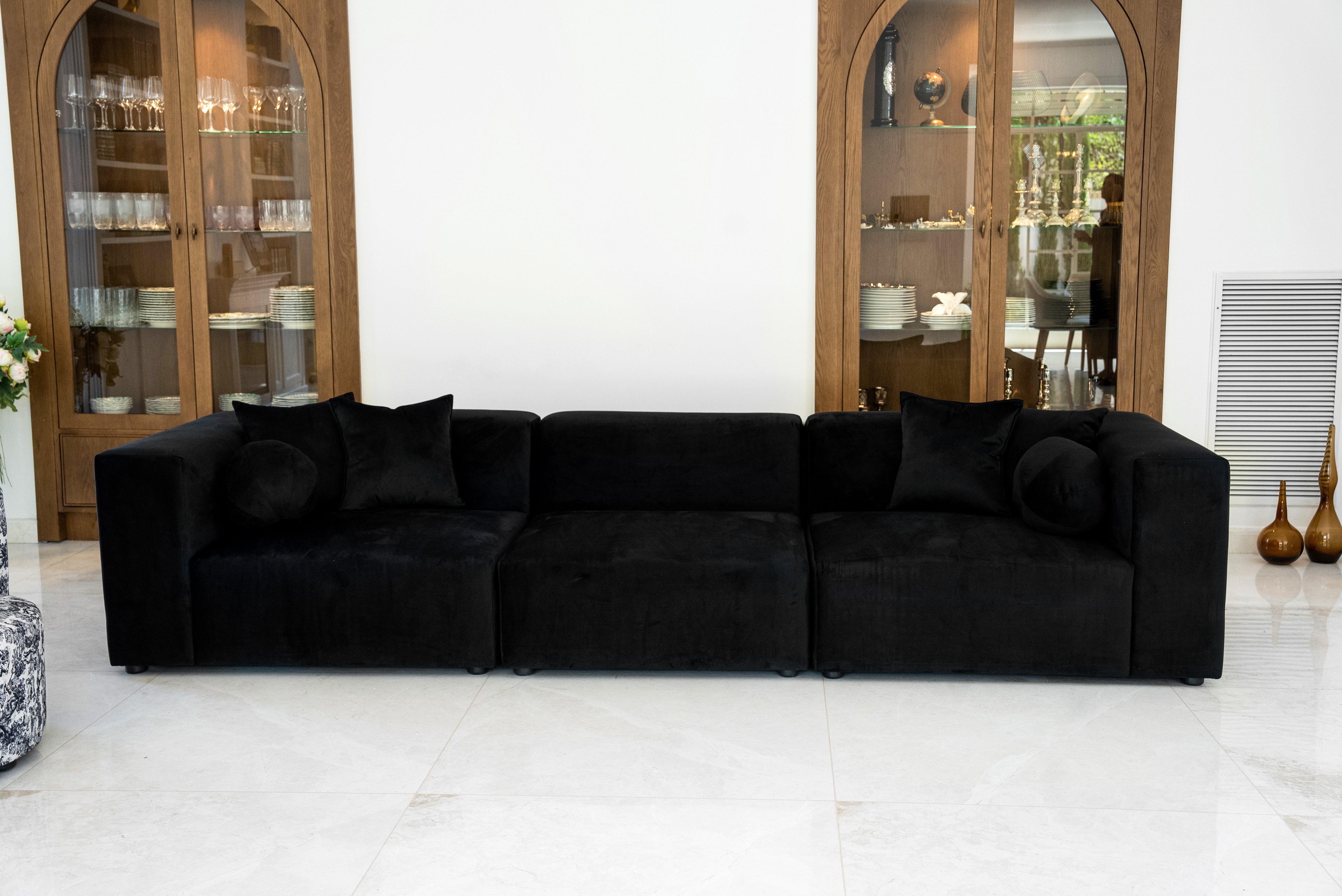 "NOIR sofa featuring luxurious black velvet upholstery, modular design with three sections, and plush cushions. Sleek modern couch set against wooden display cabinets in a bright, contemporary living space." CopyRetryDMתרגם לעבריתEditכותרת המוצר:
"ספת NOIR - ספה מודולרית אלגנטית מקטיפה שחורה לסלון מודרני"
טקסט ALT:
"ספת NOIR המציגה ריפוד קטיפה שחורה יוקרתית, עיצוב מודולרי עם שלושה חלקים, וכריות רכות ומפנקות. ספה מודרנית מסוגננת על רקע ארונות תצוגה מעץ בחלל מגורים בהיר ועכשווי." CopyRetryDMכמומחה SEO תן כותר